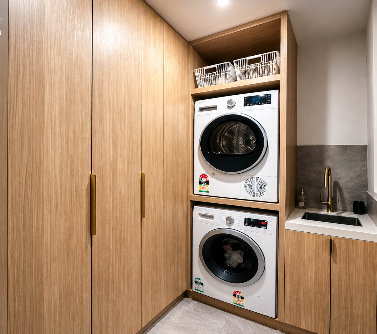 Custom laundry cabinetry with benchtop and overhead cupboards