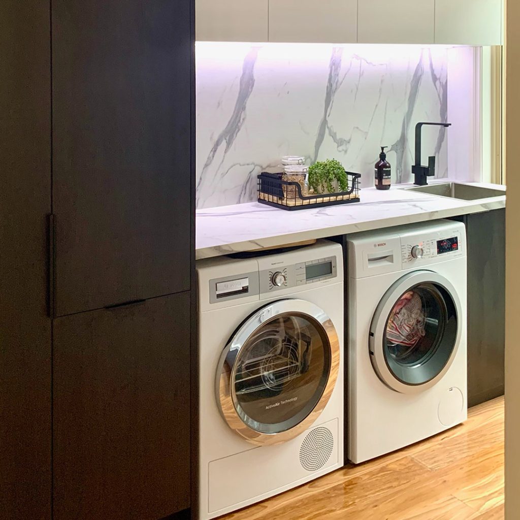 Custom laundry cabinetry with benchtop and overhead cupboards